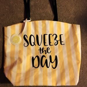 Large tote bag yellow with white stripes and black lettering.